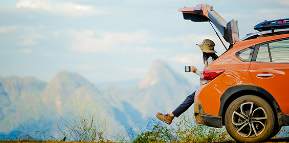 woman sitting in the back of her car looking at the mountains